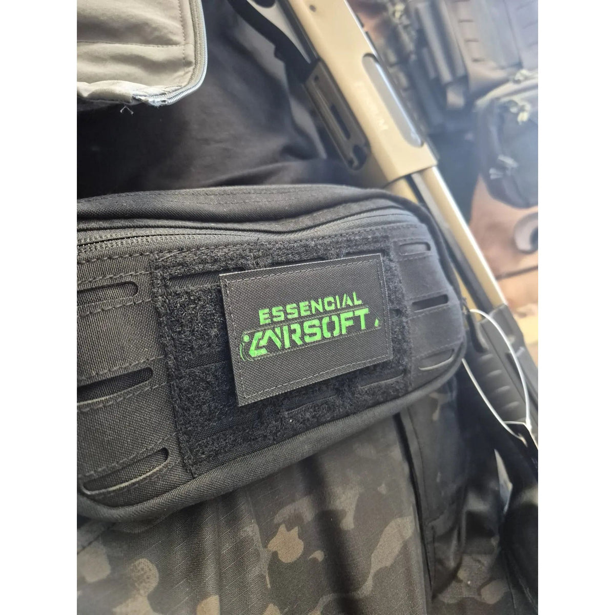 Patch Lasercut Essencial Airsoft de 8x5cm fait en France, en cordura noir sur fond vert, adaptable sur divers supports tactiques
