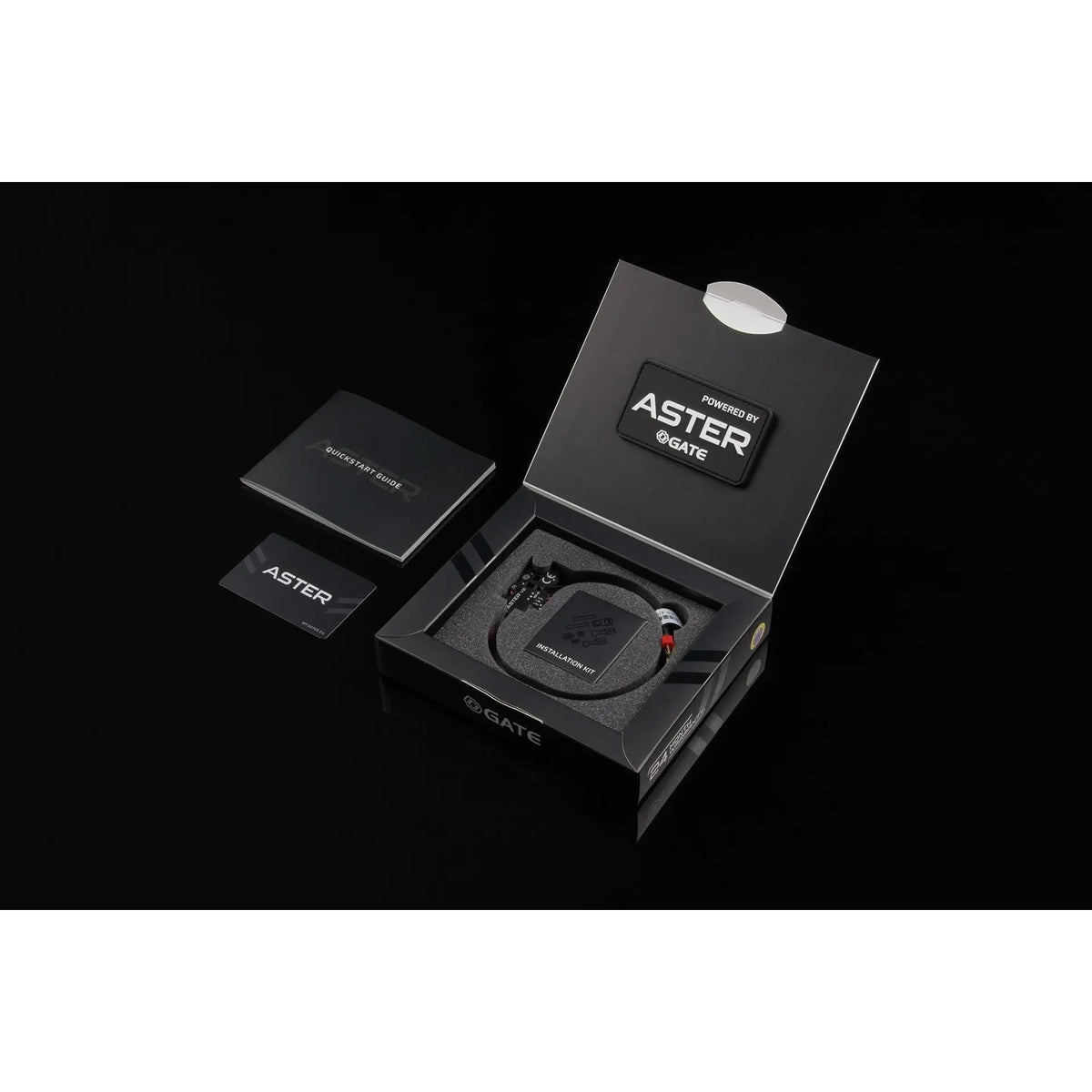 Kit d'amélioration électronique GATE ASTER V2 pour réplique airsoft avec câblage avant, comprenant un module programmable, patch, carte de programmation et guide d'installation.
